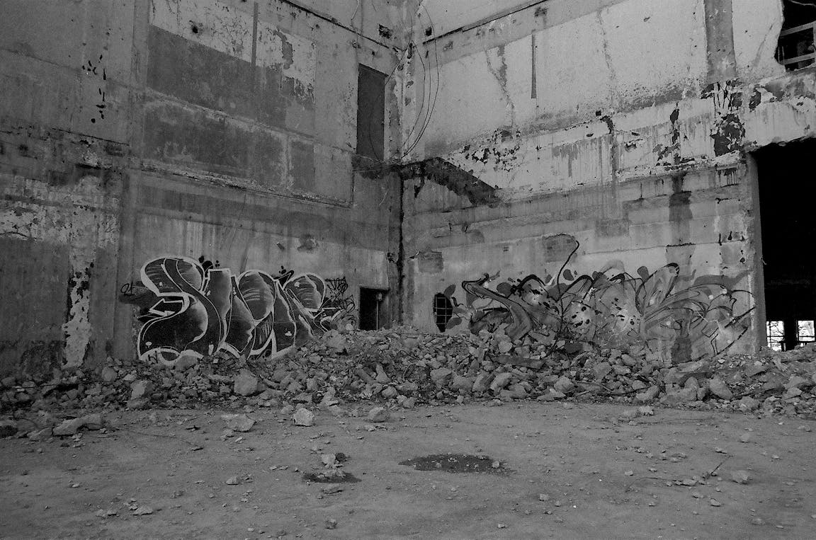 A black-and-white photo of graffiti on a building.
